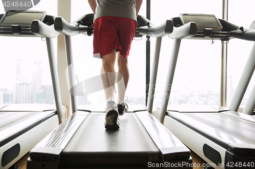 Image of man exercising on treadmill in gym