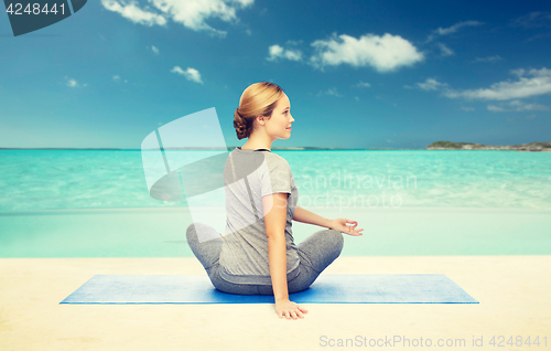 Image of woman making yoga in twist pose on mat