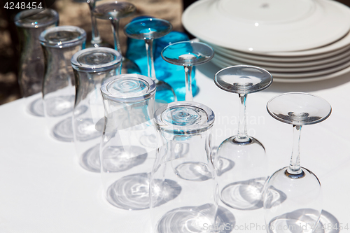 Image of many clean glasses upside down on table