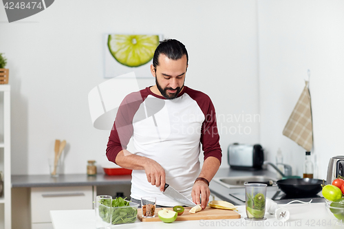 Image of man with blender and fruit cooking at home kitchen