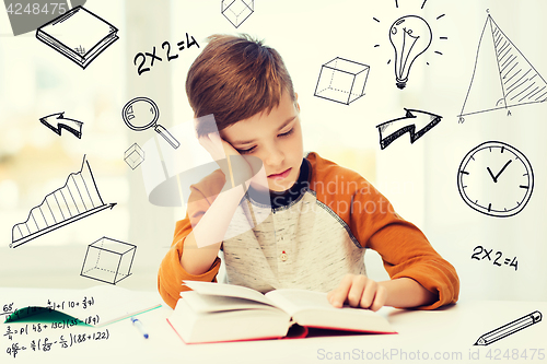 Image of student boy reading book or textbook at home