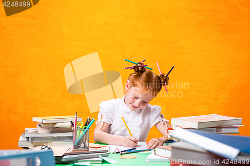 Image of The Redhead teen girl with lot of books at home. Studio shot