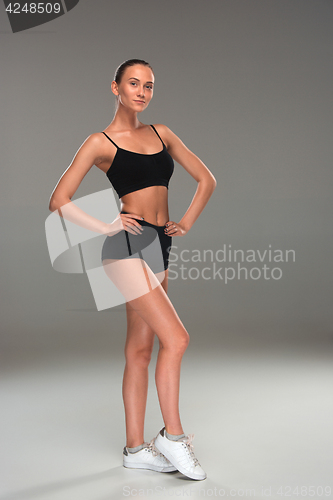Image of Muscular young woman athlete on gray