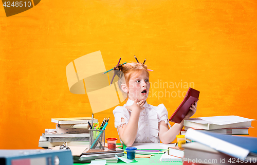 Image of The Redhead teen girl with lot of books at home. Studio shot