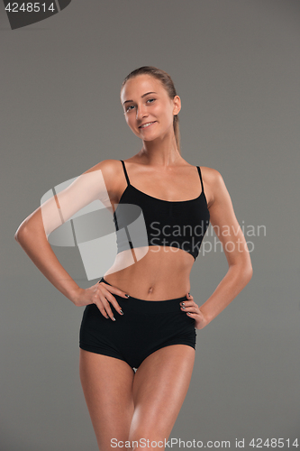 Image of Muscular young woman athlete on gray