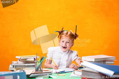 Image of The Redhead teen girl with lot of books at home. Studio shot