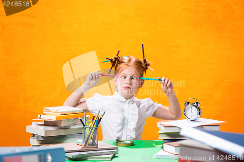 Image of The Redhead teen girl with lot of books at home. Studio shot