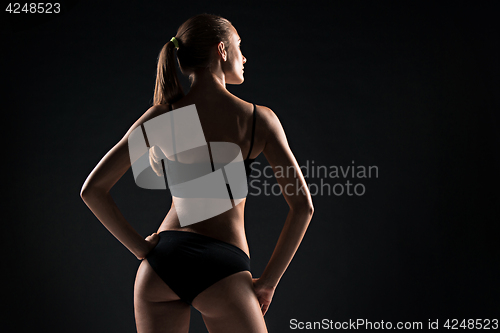 Image of Muscular young woman athlete on gray