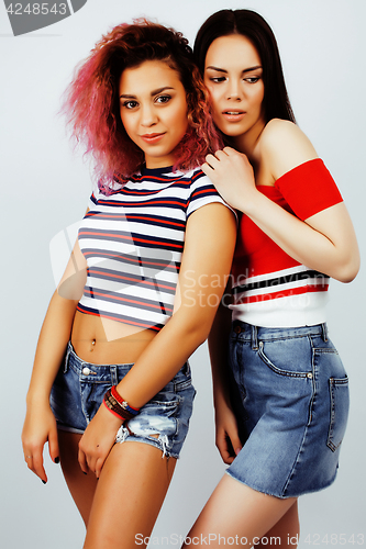 Image of lifestyle people concept: two pretty stylish modern hipster teen girl having fun together, diverse nation mixed races, happy smiling making selfie closeup