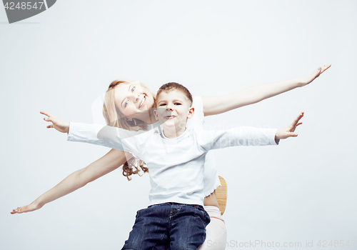 Image of young modern blond curly mother with cute son together happy smiling family posing cheerful on white background, lifestyle people concept, sister and brother friends