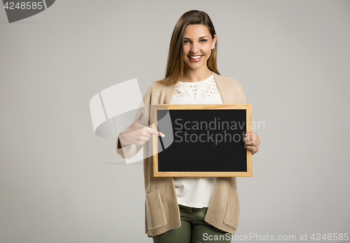 Image of Woman showing something on a chalkboard