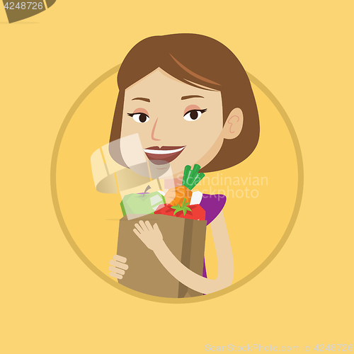 Image of Happy woman holding grocery shopping bag.