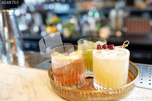 Image of tray with glasses of cocktails at bar