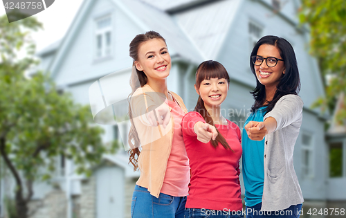 Image of international happy women pointing finger at you