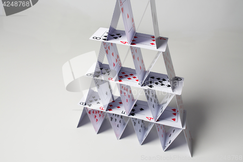 Image of house of playing cards over white background