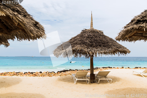 Image of palapa and sunbeds on exotic tropical beach