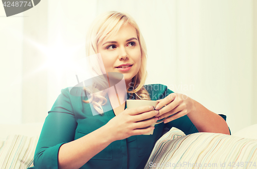 Image of happy woman  with cup of tea or coffee at home