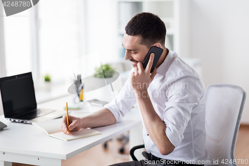 Image of businessman calling on smartphone at office