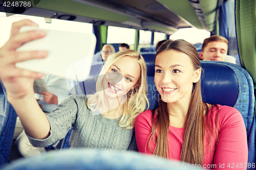 Image of women taking selfie by smartphone in travel bus