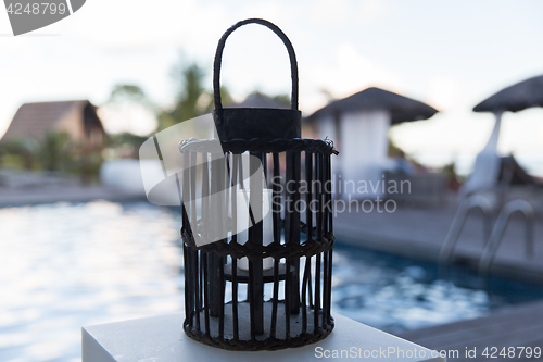 Image of lantern with candle at outdoor swimming pool