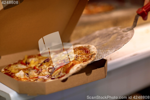 Image of chef placing pizza from peel to box at pizzeria