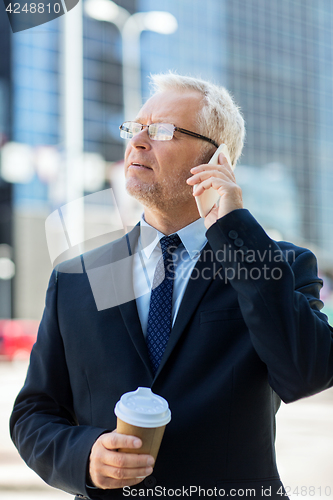 Image of senior businessman calling on smartphone in city