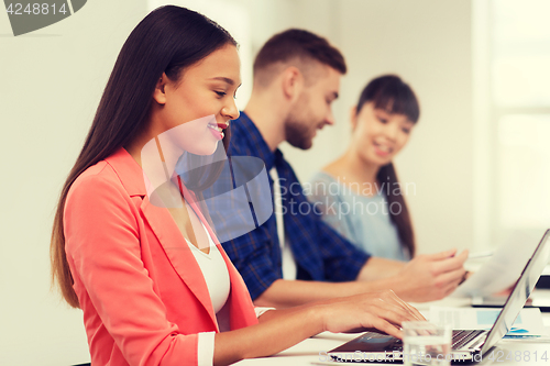 Image of happy african woman over creative team at office