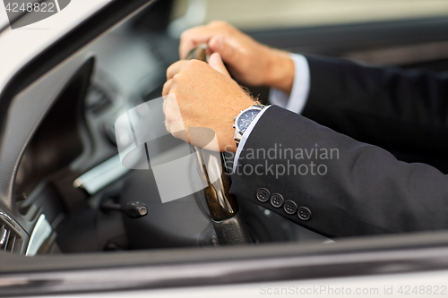Image of senior businessman hands driving car