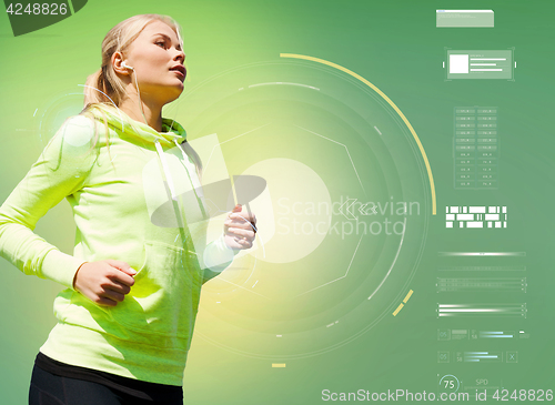 Image of young woman with earphones running over green