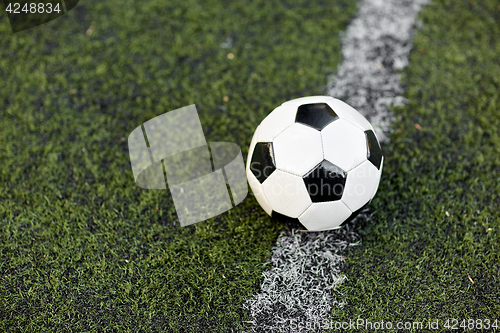 Image of soccer ball on football field marking line