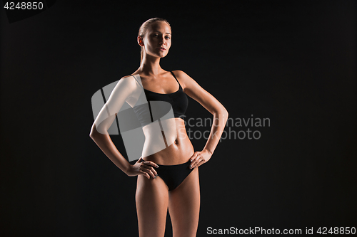 Image of Muscular young woman athlete on black
