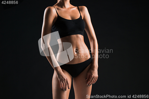 Image of Muscular young woman athlete on black
