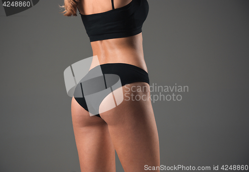 Image of Muscular young woman athlete on gray