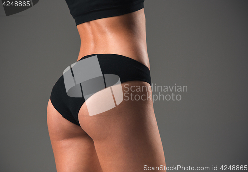 Image of Muscular young woman athlete on gray