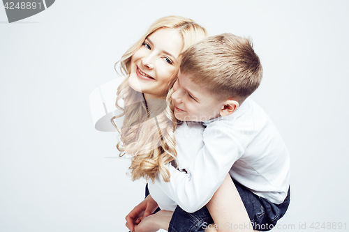 Image of young modern blond curly mother with cute son together happy smiling family posing cheerful on white background, lifestyle people concept, sister and brother friends