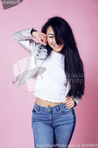 Image of young pretty smiling asian korean girl wearing modern fashion clothers on pink background, lifestyle people concept
