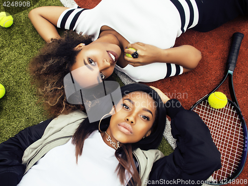 Image of young pretty girlfriends hanging on tennis court, fashion stylis