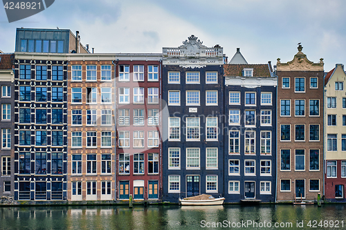 Image of Amsterdam canal Damrak with houses, Netherlands