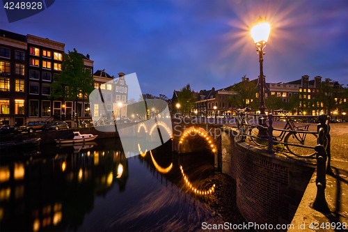 Image of Amterdam canal, bridge and medieval houses in the evening