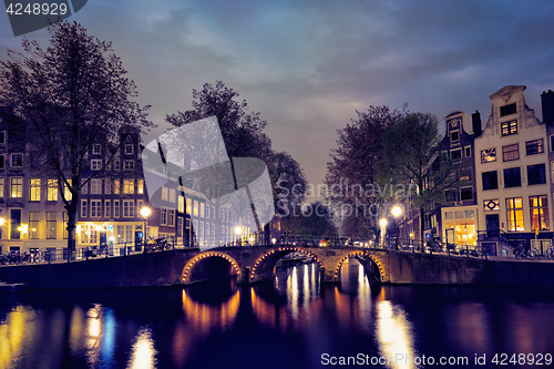 Image of Amterdam canal, bridge and medieval houses in the evening