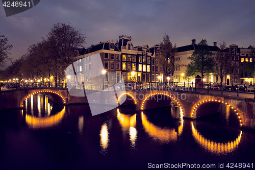 Image of Amterdam canal, bridge and medieval houses in the evening