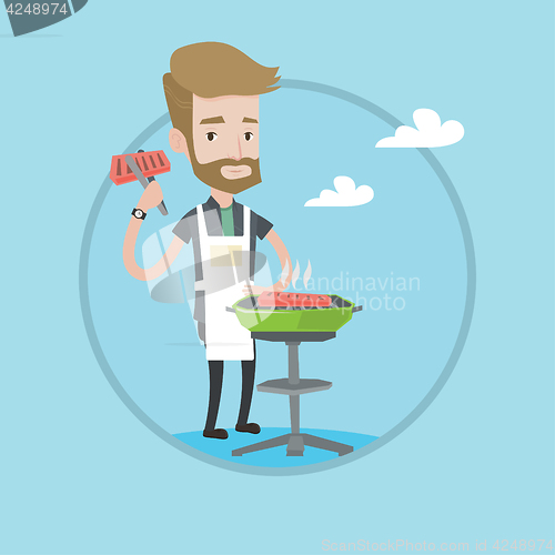 Image of Man cooking steak on barbecue grill.