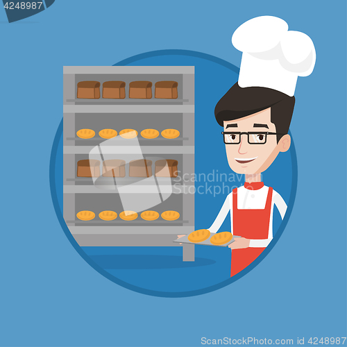 Image of Happy young male baker holding tray of bread.