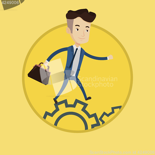 Image of Businessman running on cogwheels.