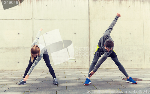 Image of close up of couple stretching on city street