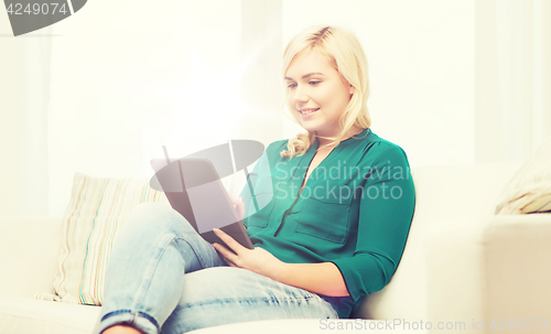 Image of smiling woman with tablet pc at home