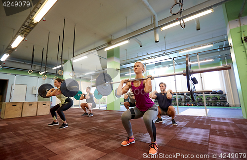 Image of group of people training with barbells in gym