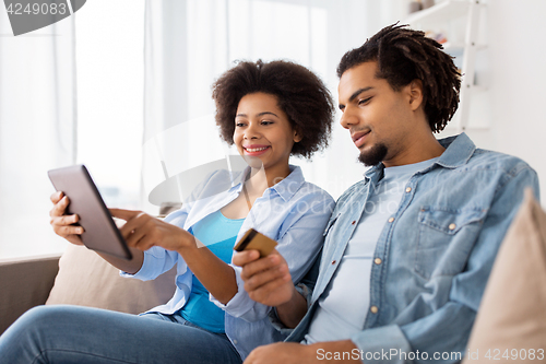 Image of couple with tablet pc and credit card at home