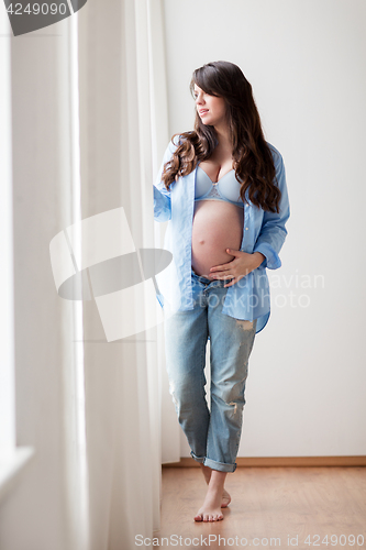 Image of happy pregnant woman with big tummy at home