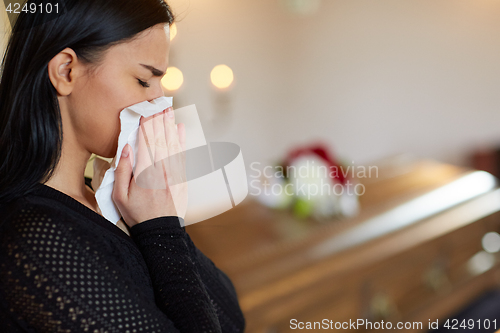 Image of woman crying near coffin at funeral in church